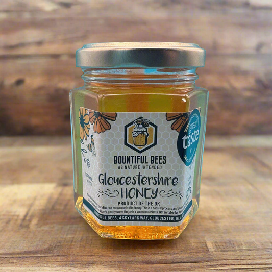 Jar of Gloucestershire honey from Bountiful Bees on a wooden surface